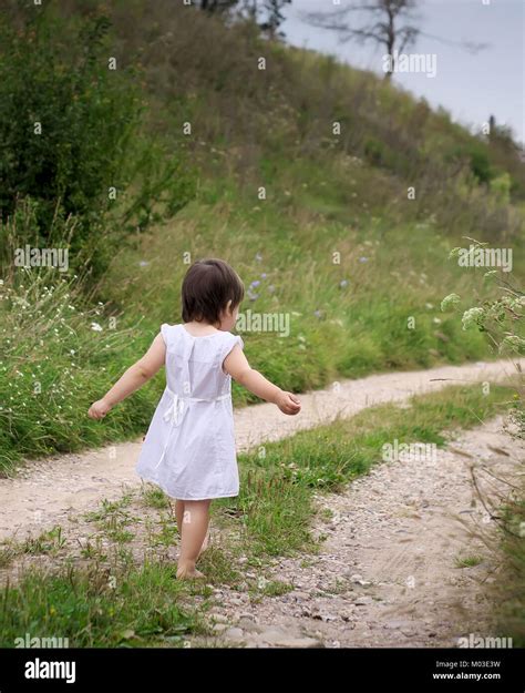 Ein Kind Geht Barfuß Auf Dem Sandigen Weg Weißen Kleid Und Barfuss Straße Sand Stockfotografie