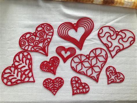 Red Paper Cutout Hearts Sitting On Top Of A White Cloth Covered Table