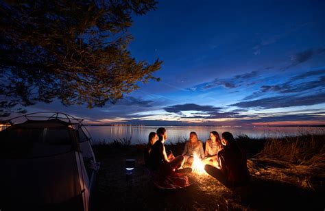 Night Summer Camping On Shore Group Of Young Tourists Around Campfire