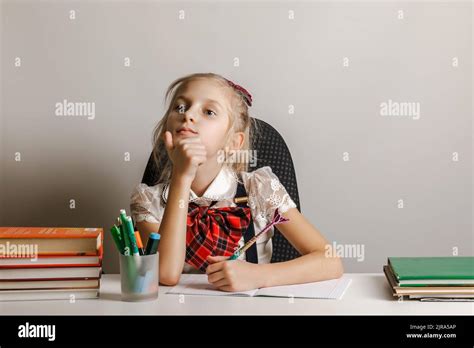 Une Petite Fille Gaucher Dans Un Uniforme Décole Est Assise à Une