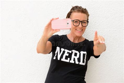Mature Nerd Woman Wearing Big Eyeglasses And Standing Against White