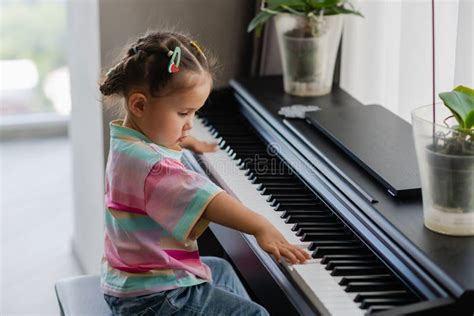 Cute Little Girl Playing Piano At A Music School Stock Photo Image Of