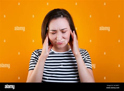 Tired Brunette Young Mixed Race Woman Keeps Hands On Temples Closes