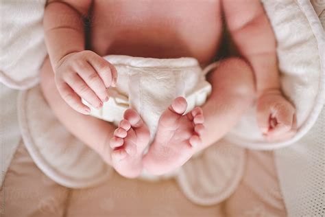 Newborn Sitting In Baby Seat With Hands And Feet Visible By Stocksy