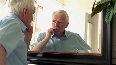 Sad Senior Man Standing In Front Of The Mirror Stock Video Footage 00
