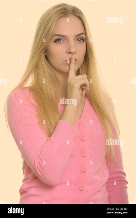 Studio Shot Of Young Beautiful Teenage Girl With Finger On Lips Stock