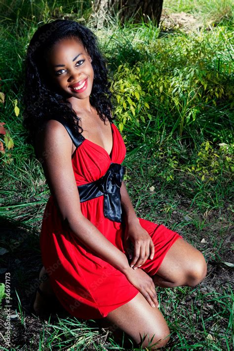 African American Woman Kneeling In Grass Outside Stock Photo Adobe Stock