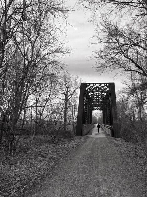 Premium Photo Person Walking Alone On Dirt Road On Footbridge