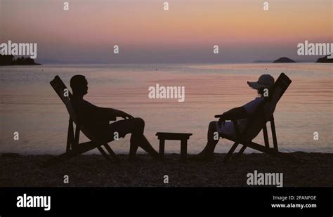 Romantic Couple Sit On Chair On Beach Magical Scenery Colored Sunset