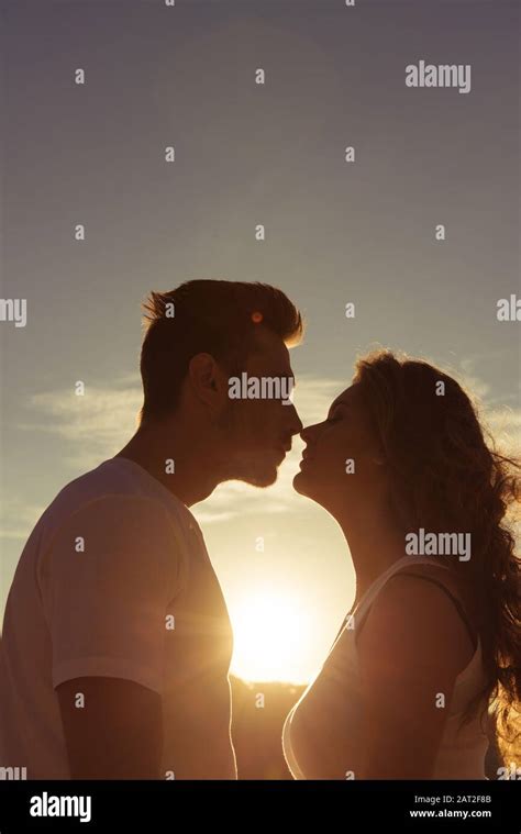 Close Up Portrait Of Two Young Lovers Kissing On The Sunset Stock Photo