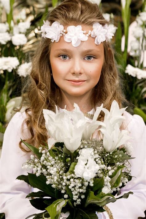 Portrait Of Cute Little Girl On White Dress And Wreath On First Holy