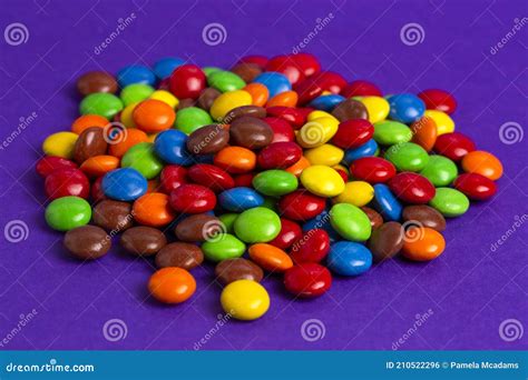 Pile Of Rainbow Colored Candy Coated Chocolate Buttons Stock Photo
