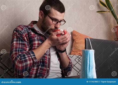 Quarantine Guy Working At Home With A Laptop With A Cup Of Coffee