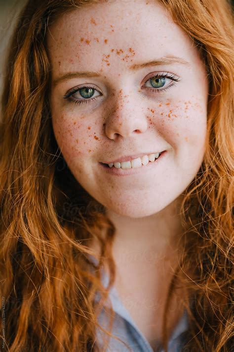 Close Up Portrait Of A Teenage Girl With Freckles And Ginger Hair Biting Her Lip By Stocksy