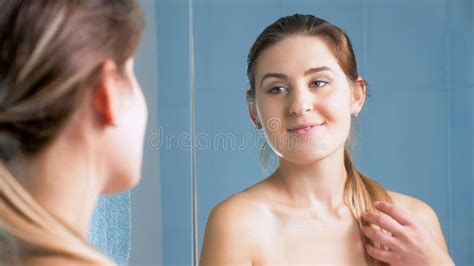 Portrait Of Beautiful Brunette Woman Posing In Bathroom At Mirror Stock