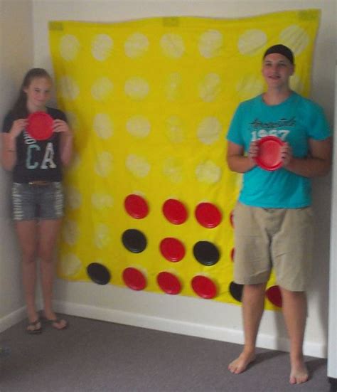 Two People Standing In Front Of A Giant Board With Circles On It And