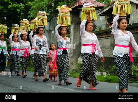 A Balinese Temple Anniversary Procession With Women Carrying Beautiful