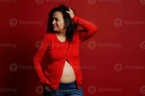 Portrait Of Multi Ethnic Mature Pregnant Woman In Red Shirt Looking