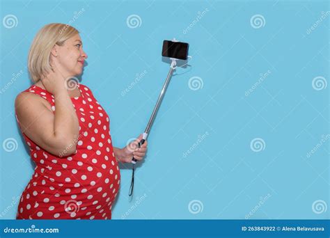 Pregnant Woman Taking Selfie On Blue Background With Copy Space Stock