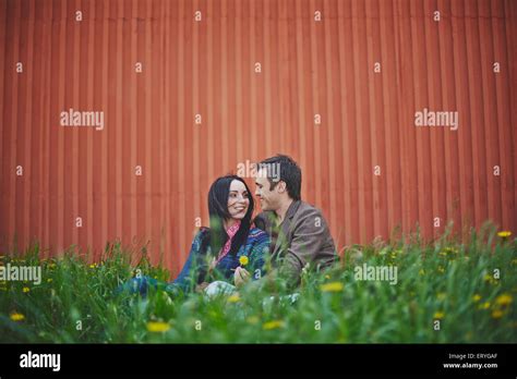 Happy Couple Sitting In Green Grass Stock Photo Alamy
