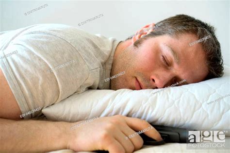 Man Sleeping In Bed With Gun In His Hand Stock Photo Picture And Low