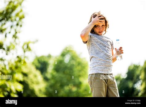 Niño sosteniendo una botella de agua en el parque retrato Fotografía