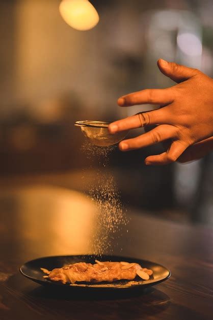 Premium Photo Closeup Of Hands Of Young Chef Sprinkling Powdered