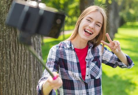 Chica Tomando Una Selfie Con Su Teléfono Al Aire Libre Foto Gratis