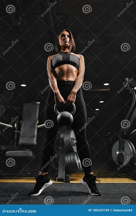 fitness woman exercising crossfit holding kettlebell strength training biceps beautiful sweaty