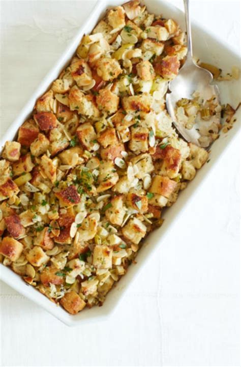 A Casserole Dish Filled With Stuffing And Topped With A Spoon