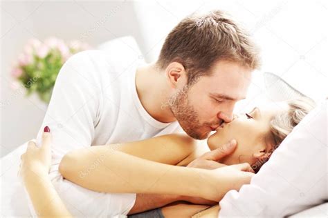 Uploaded at july 21, 2020. Young couple kissing in bed — Stock Photo © macniak #136599708