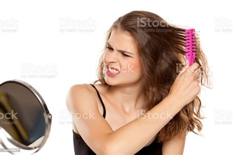 Young Beautiful Nervous Woman Have A Problem With Combing Her Hair On