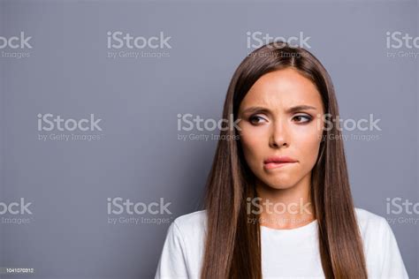 Close Up Portrait Of Frustrated Girl Bite Her Lip Isolated On Gray
