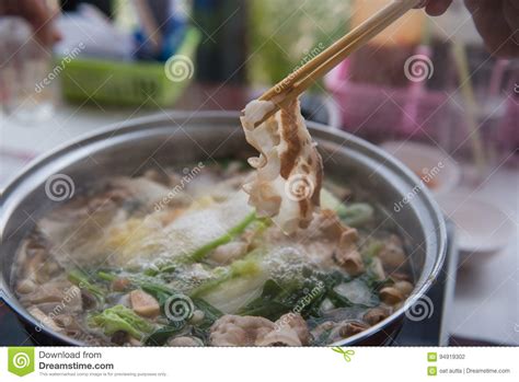 Shabu Shabu Or Sukiyaki Or Hot Pot Hand Holding Pork Using Chopsticks