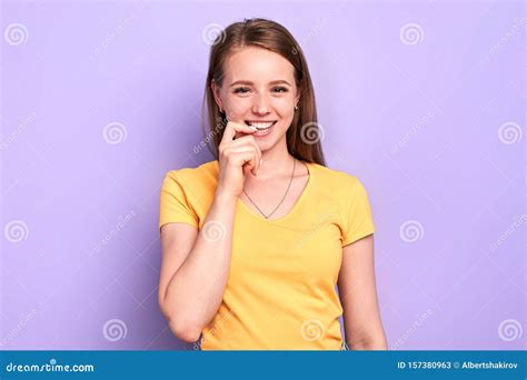 Playful Girl With Intriguing Face Expression Keeps Hand Near Lips