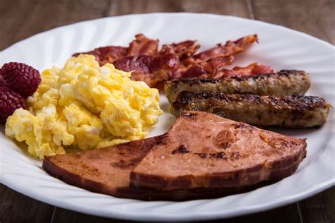 Plate Of Breakfast Scrambled Eggs Bacon Sausage And Ham 2 Stock
