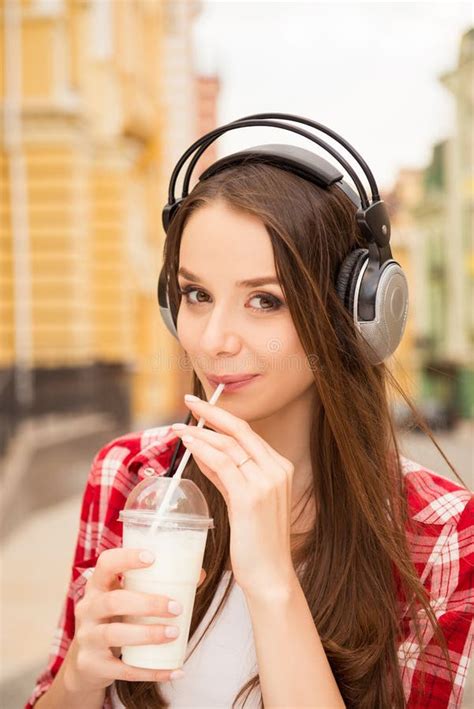 Pretty Casual Girl With Headphones Drinking Milkshake Stock Photo