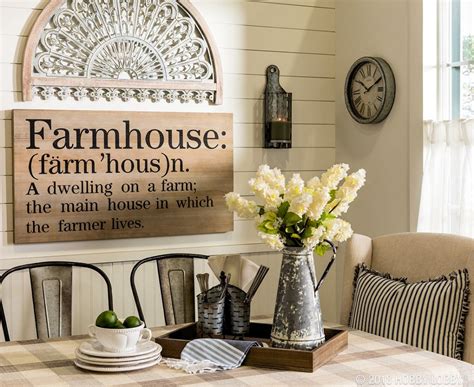A Dining Room Table With Flowers In A Vase On It And A Farmhouse Sign