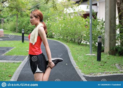 Healthy Asian Woman Stretching Her Legs Before Run In Park Fitness And