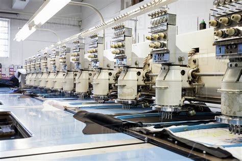 Rows of programmed embroidery machines speed stitching in clothing ...