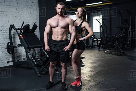 Young fit couple in sportswear posing together at gym - Stock Photo ...