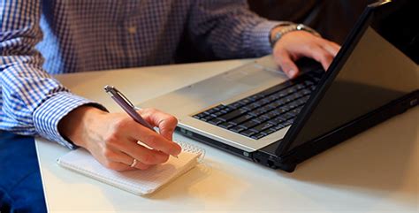 Man Working On Laptop And Writing In A Notebook By Mnacik Videohive