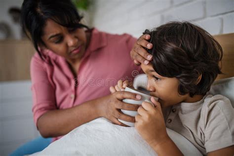 Madre Cuidando A Su Hijo Enfermo En Casa Imagen De Archivo Imagen De