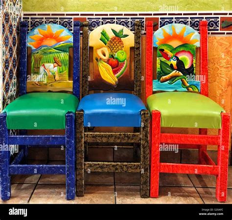 Three Chairs Hand Carved And Painted In Mexican Restaurant Stock Photo