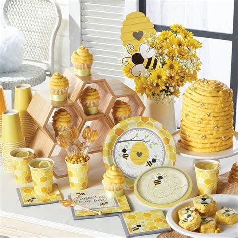 A Table Topped With Plates And Cups Filled With Yellow Desserts Covered