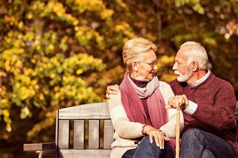 Older Couple Sitting On Park Bench Stock Photo Image Of Autumn