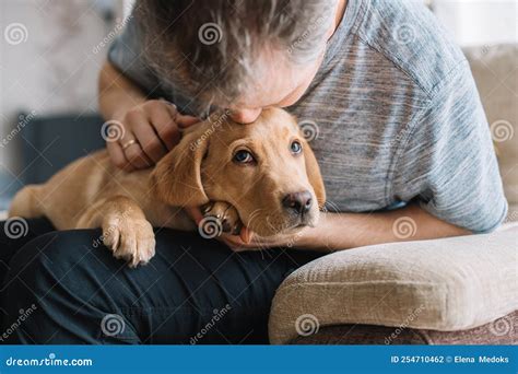Young Man Hugging His Labrador Retriever Puppy The Concept Of