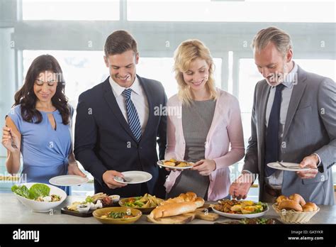 Business Colleagues Serving Themselves At Buffet Lunch Stock Photo Alamy