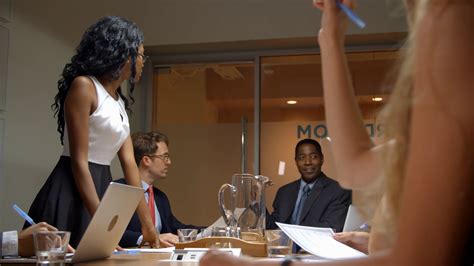 Young Black Woman Stands To Address Team At Business Meeting Stock