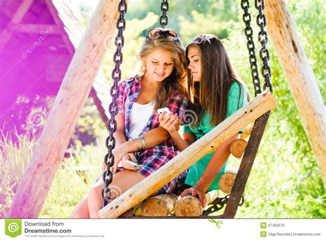 Gelukkige Twee Tieners In Openlucht And Mobiele Telefoon Stock Foto